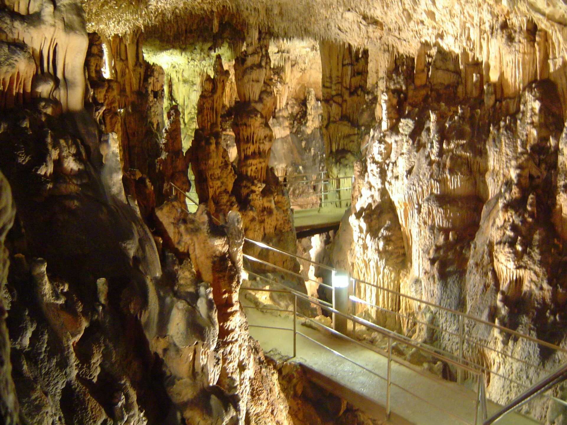 Illuminated limestone formations and the visitor path inside Biserujka Cave on Krk